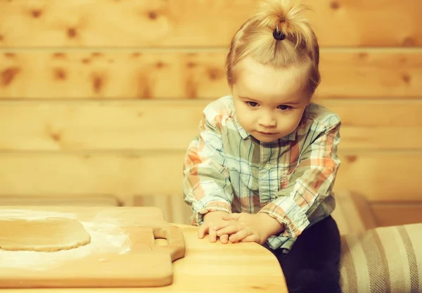 Criança bonito na camisa quadriculada cozinhar com massa e farinha — Fotografia de Stock