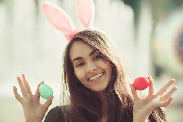 Meisje met roze bunny oren poseren met gekleurde eieren, — Stockfoto