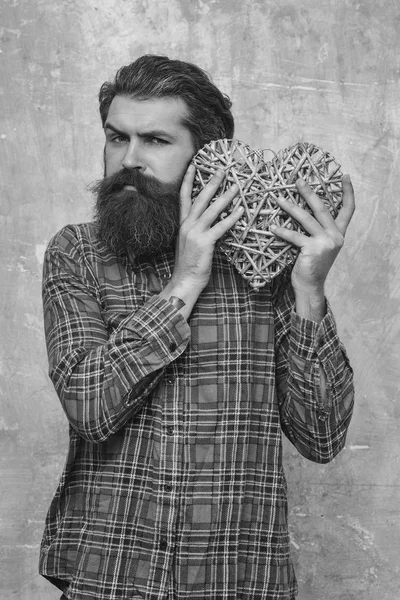 Бородатый человек с длинной бородой держит плетеное сердце — стоковое фото