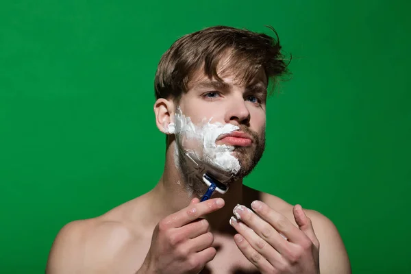 スキンケア シェービング クリームや顔の皮膚上の泡を学士 グルーミング 朝ルーチンのコンセプトです 緑の背景にかみそりで剃るひげの髪を男 — ストック写真