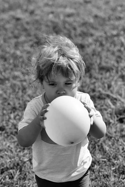 Малыш играет с розовым шариком игрушки — стоковое фото