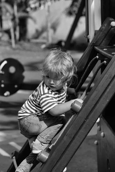 Söt baby pojke klättra rep netto eller stege — Stockfoto