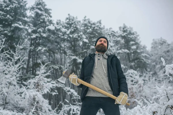 Homem barbudo com machado na floresta nevada . — Fotografia de Stock