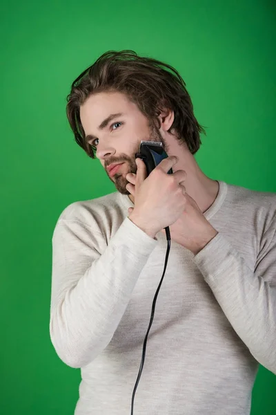 Man trimmen baard haar met elektrisch scheerapparaat. — Stockfoto