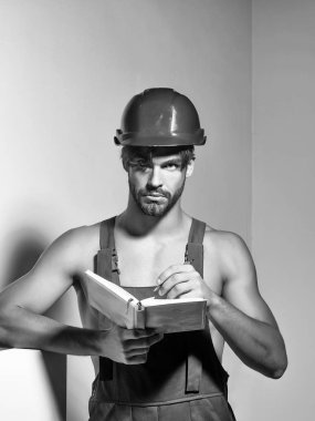 Yakışıklı adam Oluşturucu tamirci usta foreman veya inşaat işçisi turuncu kask ve genel muhasebe defteri gri arka plan üzerinde tutar