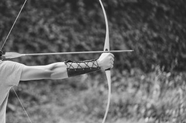 Archer eller yay ile ok ile mavi ve sarı fletchings doğal zemin üzerine ateş.