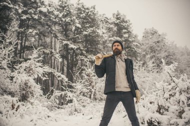 Kışın, sakal sıcak kış aylarında Cilt Bakımı ve sakal bakımı. Kamp, seyahat ve kış dinlenme. Adam oduncu balta ile. Isı, soğuk, soğuk dalgası, kar yağışı. Sakallı adam karlı ormanda balta ile.