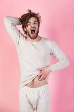 Pembe bir arka plan üzerinde sakallı uykulu adam.