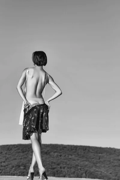 Young woman undressing on blue sky — Stock Photo, Image