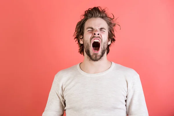 Sleepy man with beard on red background.