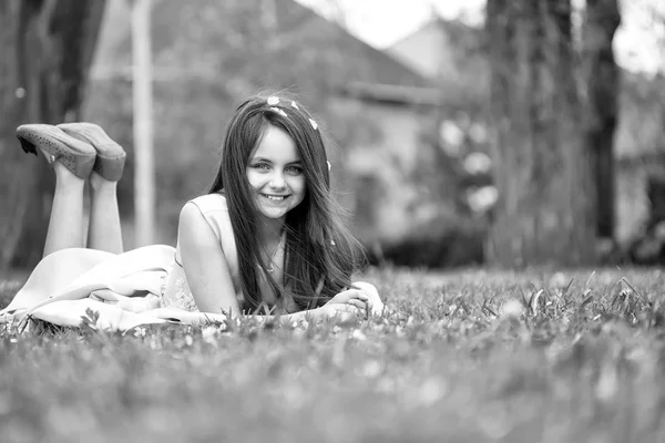 Petite fille sur herbe verte avec des pétales — Photo