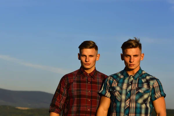 Hombres gemelos al atardecer o al amanecer, amistad. — Foto de Stock
