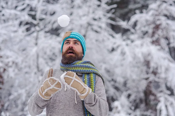 Bebaarde hipster spelen met sneeuwbal in het besneeuwde forest — Stockfoto