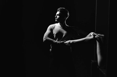 Yakışıklı adam veya şık saç kesimi, saç, seksi, çıplak, kadın bacak ile poz ile genç beyaz maço siyah arka plan üzerine, kopya alanı eller