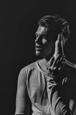 Yakışıklı adam ya da şık saç kesimi, saç, uzun kollu, sıradan gri tshirt ile genç beyaz maço giyim, seksi, kadın bacak ile poz, yalınayak, yüzündeki siyah arka plan üzerine ayak