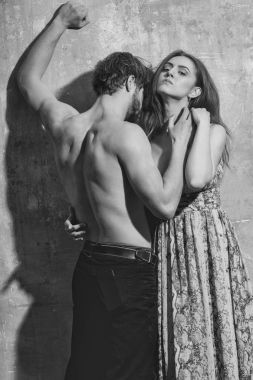 Seksi genç birkaç yakışıklı adam ya da çıplak gövde, pazı, triceps, güzel bir kız ya da uzun saçlı güzel kadın bej grunge duvara sarılma ile kas maço