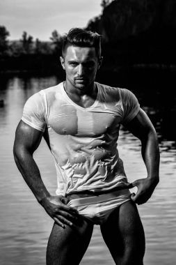 yakışıklı genç maço adam kaslı seksi vücut ve pantolon ve ıslak gömlek güneşli bir gün su doğal zemin üzerine açık gövde üzerinde altı paketleri ile