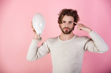 düşünceli adam pembe arka plan, bir fikir vardır sabah. Enerji ve elektrik kavramı. Dağınık saçlı adam büyük lamba tutun. Çözüm ve karar. Güç ve iş başarı.