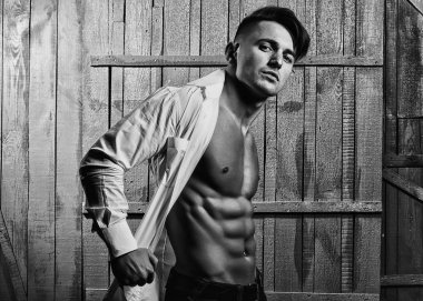 Seksi ciddi şehvetli kas genç maço adam ahşap arka planda, yatay resim kapalı duran Beyaz gömlekli çıplak gövde ile