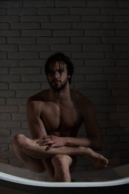 Banyo ve ev konfor. Hijyen ve sağlık. Banyo kas vücut olan adam. Spa ve rahatlama, seksi bir adam. Küvet içinde oturan ıslak saçlı çocuk.