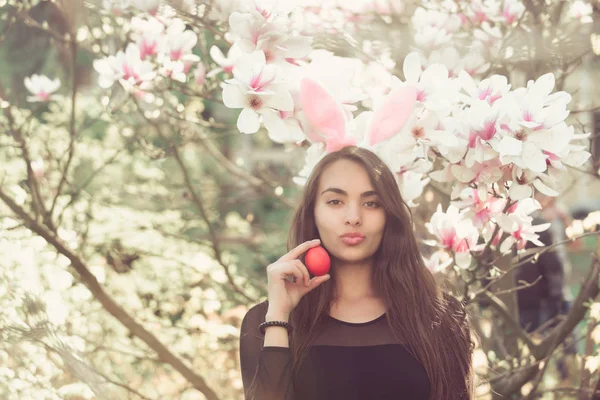 Easter egg in handen van vrouw met pluche lippen, magnolia — Stockfoto