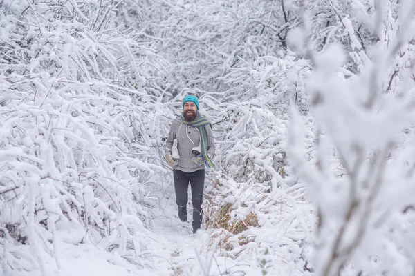 Homem barbudo com patins na floresta nevada . — Fotografia de Stock