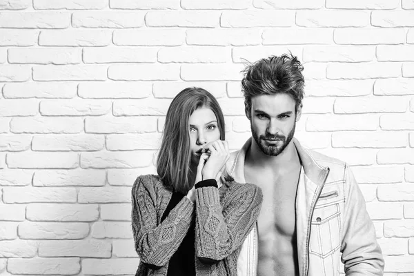 年轻夫妇的肌肉强壮男子在解压缩夹克和可爱的女孩或针织外套上白砖背景美丽的女人或英俊的男人 — 图库照片