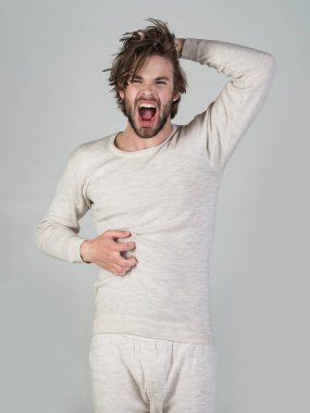 Uykusuzluk, enerji, uncombed saçlı tek. İç çamaşırı dağınık saçlı adam. Sabah Uyan, günlük hayatın. Gri arka plan üzerinde sakallı uykulu adam. Berber ve Kuaför, erkek moda.