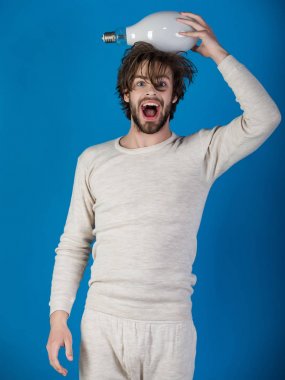 Mutlu adam vardır mavi arka plan, bir fikir sabah. Dağınık saçlı adam büyük lamba tutun. Çözüm ve karar. Güç ve iş başarı. Enerji ve elektrik kavramı.