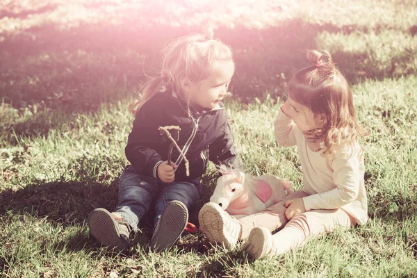 Hermano y hermana se sientan sobre hierba verde —  Fotos de Stock