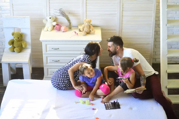 Rodina s veselou tváří sedí ve stylové ložnici — Stock fotografie