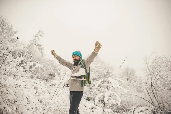 Bebaarde man met schaatsen in het besneeuwde forest. — Stockfoto