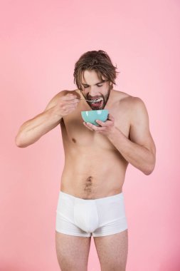 Islak saçlı adam yemek Kahvaltı, pembe arka plan.