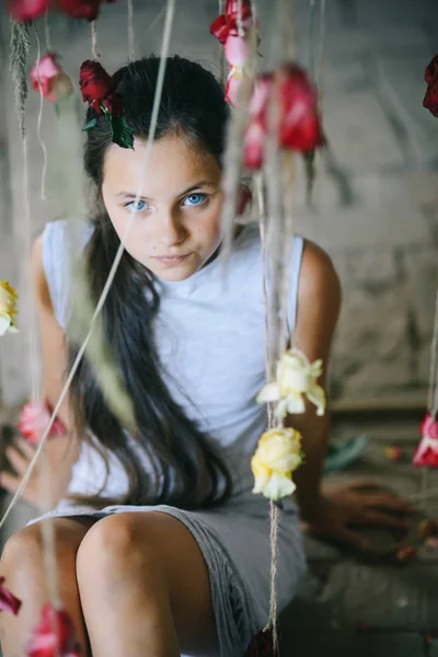 Чарівна дівчинка в ніжному інтер'єрі зі свіжими квітами . — стокове фото