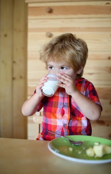 Kleine jongenskind eet banaan en drinken melk. — Stockfoto