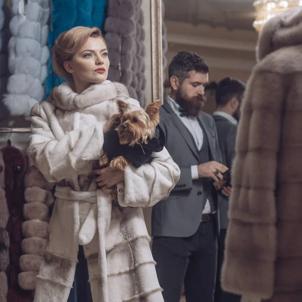 Woman in fur coat with man, shopping, seller and customer.