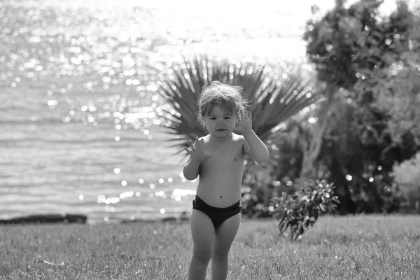 Lindo bebé niño da cinco con las manos en la hierba verde — Foto de Stock