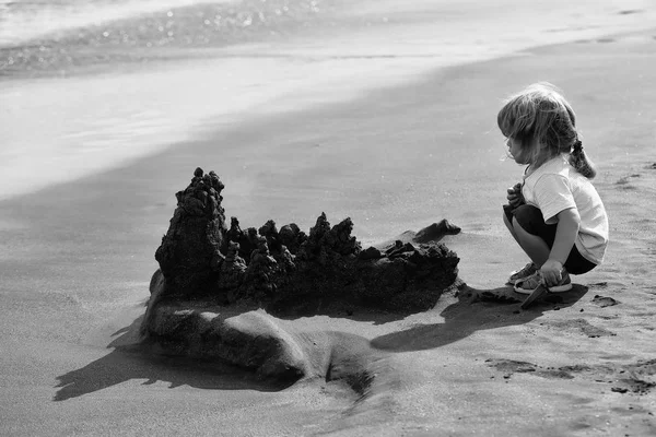 Lindo bebé niño construye castillo de arena en la playa del mar — Foto de Stock