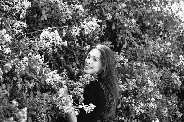 Bella ragazza tra i fiori in fiore — Foto Stock