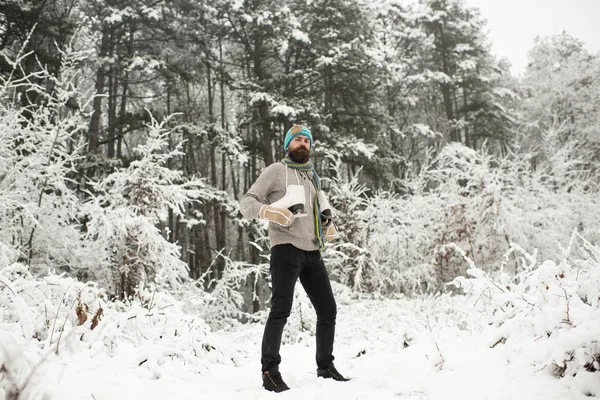 Bebaarde man met schaatsen in het besneeuwde forest. — Stockfoto
