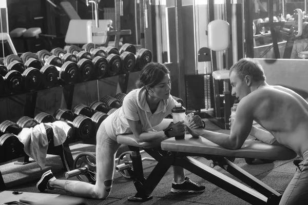 Braccio di ferro muscolare uomo e ragazza in palestra — Foto Stock