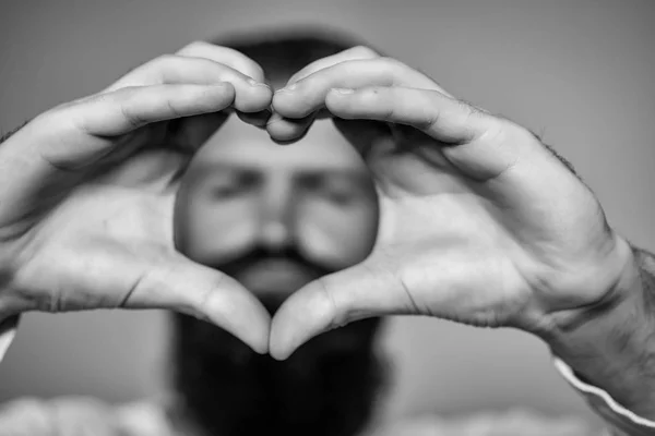 Бородатый мужчина с руками в форме сердца — стоковое фото
