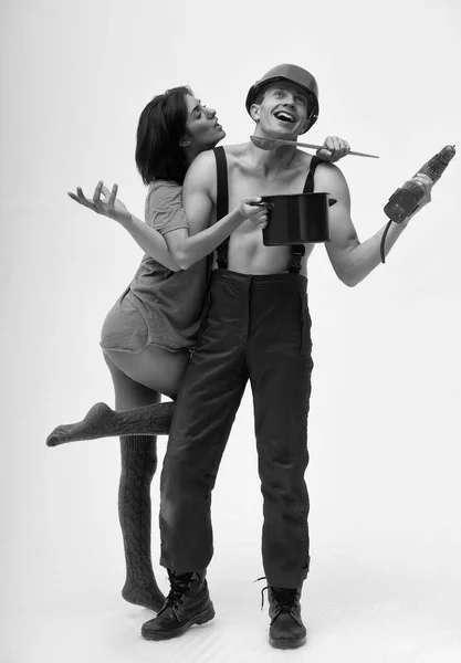 Casa pareja de musculoso hombre y mujer sostiene la olla, taladro — Foto de Stock