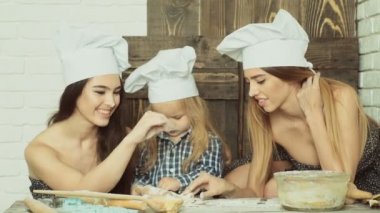 Lezbiyen çift ile onların evlat edinilmiş çocuk yemek. Kız onların kardeşi ile pişirme.