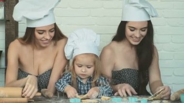 Lezbiyen çift ile onların evlat edinilmiş çocuk yemek. Kız onların kardeşi ile pişirme.