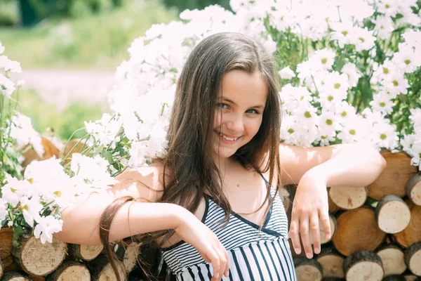 Belleza niño sonrisa con flores de margarita en el día soleado, primavera — Foto de Stock