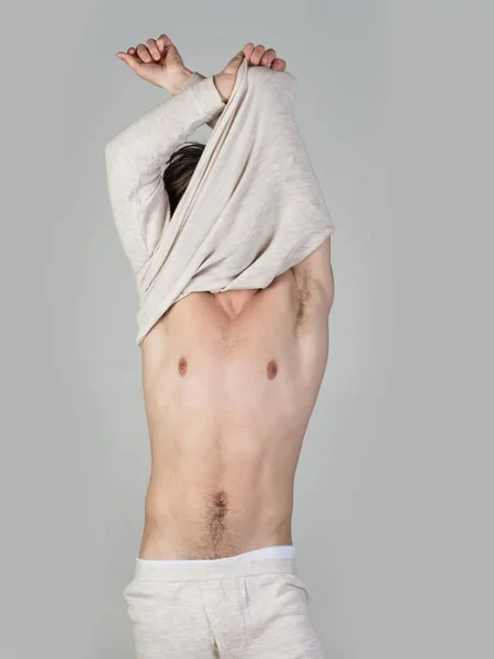 Hombre somnoliento desnudarse sobre fondo gris . — Foto de Stock
