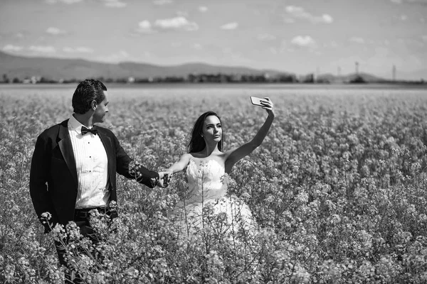 Casal de casamento no campo flores amarelas — Fotografia de Stock