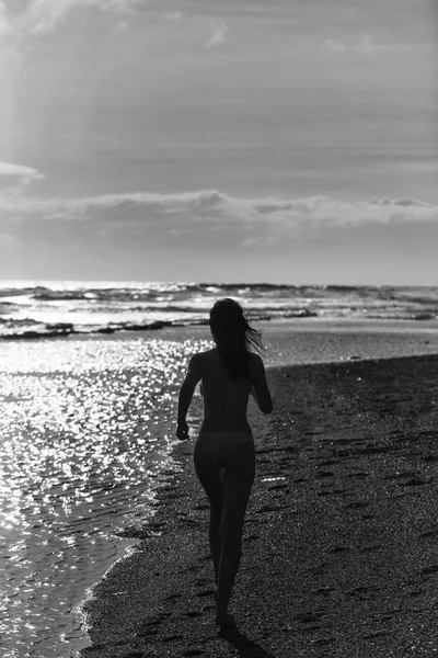 砂浜のビーチを走る黄色い水着でかわいい女の子 — ストック写真