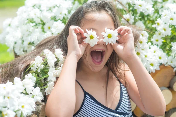 Ευτυχισμένο παιδί με Μαργαρίτα μάτια στον κήπο την άνοιξη — Φωτογραφία Αρχείου